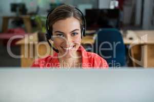 Portrait of female executive with headphones at creative office