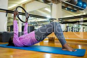 Fit woman exercising with pilates ring on mat