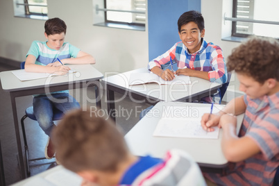 Schoolboy sitting at desk in classroom