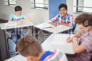 Schoolboy sitting at desk in classroom