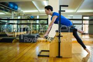 Determined woman exercising on wunda chair