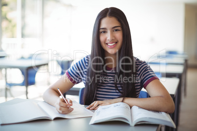 Schoolgirl doing homework in classroom