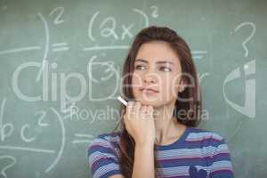 Thoughtful schoolgirl pretending to be a teacher in classroom