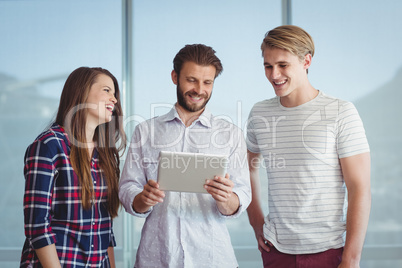 Business executives discussing over digital tablet Business executives discussing over digital tablet