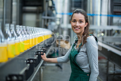 Female factory worker standing near production line