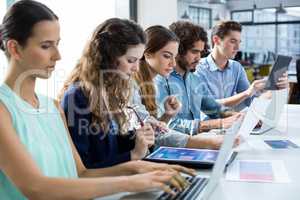 Business team working on laptop and digital tablet in meeting