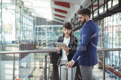 Executives discussing over digital tablet on platform