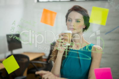 Thoughtful female executive looking at sticky notes