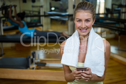 Portrait of beautiful fit woman using mobile phone after workout