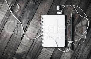 Blank notebook, pencil and headphones