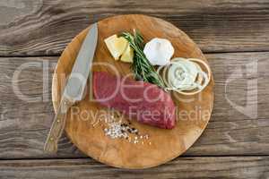 Beef steak and ingredients on wooden tray against wooden background