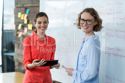 Business executives standing with digital tablet in office