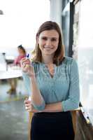 Portrait of businesswoman standing with marker