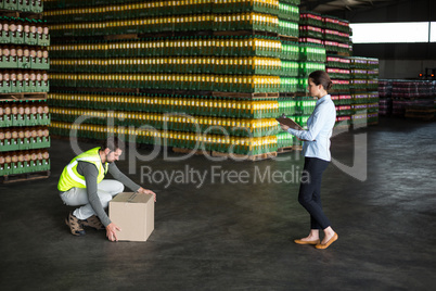 Factory worker maintaining record on clipboard in factory