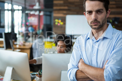 Man with arms crossed standing in office