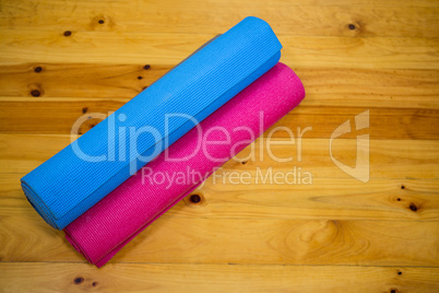 Rolled-up exercise mat on wooden floor