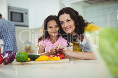 Mother and daughter preparing salad in kitchen