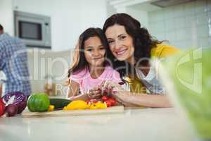 Mother and daughter preparing salad in kitchen