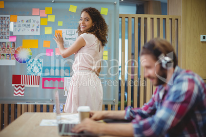 Portrait of female graphic designer standing near whiteboard