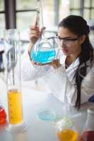 Attentive schoolgirl doing a chemical experiment in laboratory