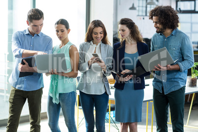 Group of business executives using digital tablet, mobile phone and laptop