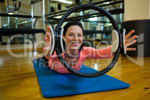 Portrait of happy woman exercising with pilates ring
