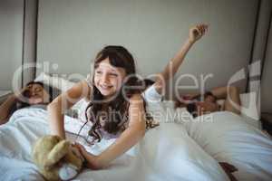 Girl stretching her arms in bed