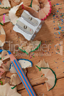 Close-up of sharpener and colored pencil with shavings