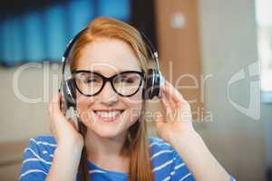 Female graphic designer listening music on headphones