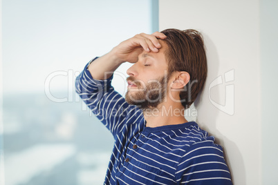 Sad business executive leaning on wall