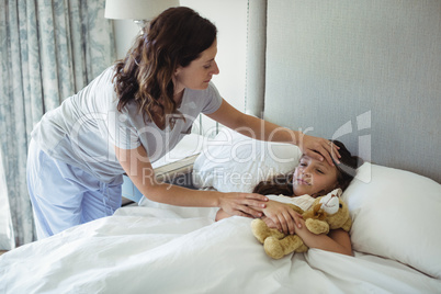 Mother making her daughter sleep in bedroom