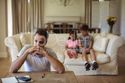 Thoughtful man sitting in living room