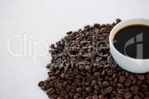 Cup of black coffee with roasted coffee beans