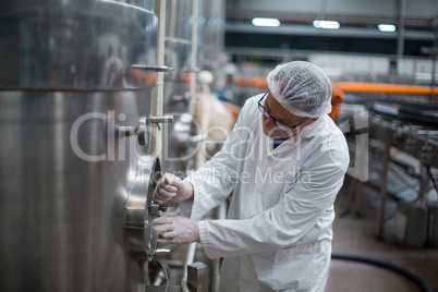 Factory engineer turning control wheel of storage tank