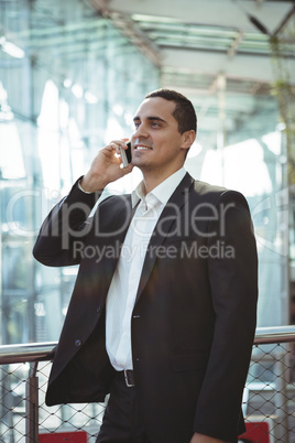 Businessman talking on mobile phone on platform