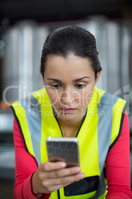 Female factory worker using mobile phone