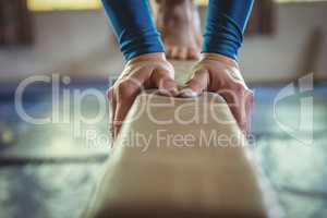 Female gymnast practicing gymnastics on the balance beam