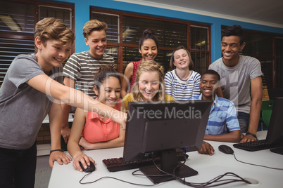 Smiling students studying together in computer classroom