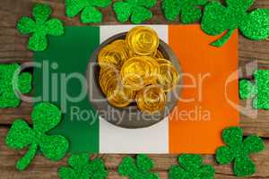 St. Patricks Day pot of chocolate gold coins and irish flag surrounded by shamrock