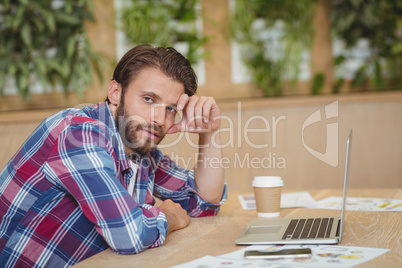 Portrait of tensed business executive with laptop siting at desk