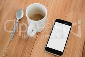 Coffee, mobile phone and spoon