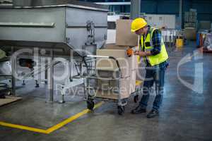 Factory worker loading cardboard boxes