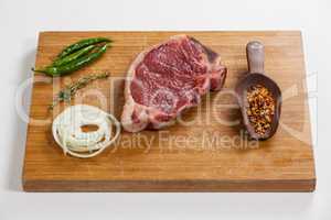 Sirloin chop and ingredients on wooden board
