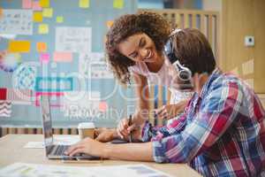 Graphic designers discussing over laptop