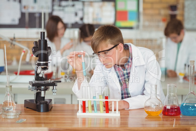 Attentive schoolboy doing a chemical experiment in laboratory Attentive schoolboy doing a chemical experiment in laboratory
