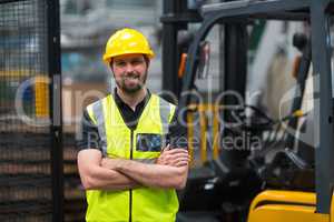 Factory worker standing with arms crossed in factory