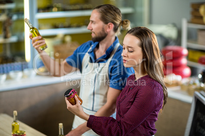 Shop assistants looking at olive oil and pickle bottles