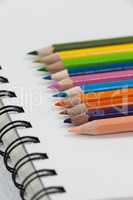 Close-up of colored pencils and notebook