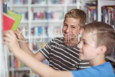 Schoolboys selecting book in library
