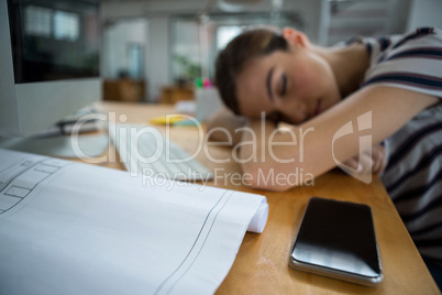 Overworked graphic designer sleeping on his desk